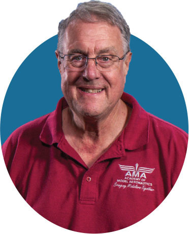 Smiling man in red AMA polo shirt, blue circular background.