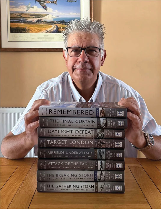 Man holding a stack of books titled "Remembered," "The Final Curtain," and others.