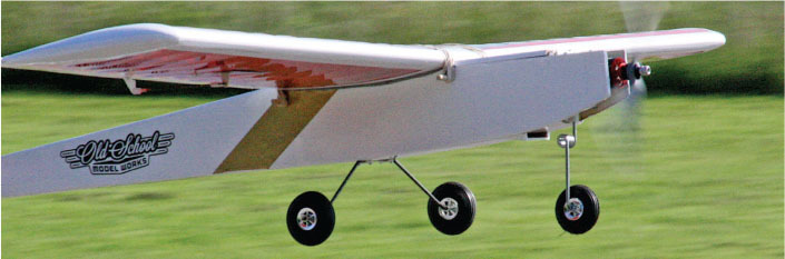 Model airplane flying over grass, "Old School Model Works" text visible.