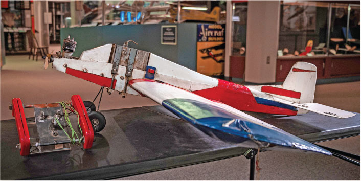 Model airplane with red, white, and blue design, displayed indoors.
