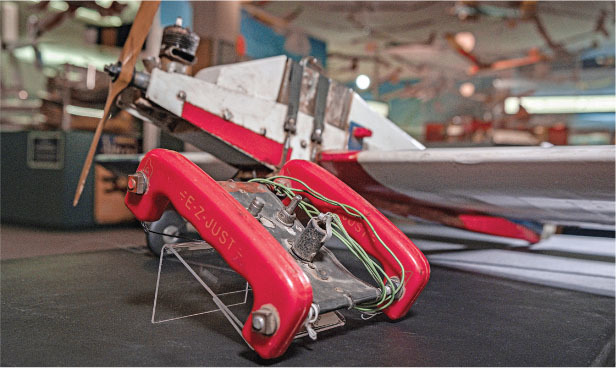 Red and silver mechanical device with a propeller and visible wiring.