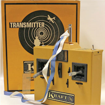 Yellow Kraft transmitter with levers, and a box labeled "Transmitter" with a plane graphic.