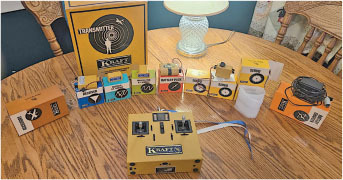 Vintage electronics set on wooden table with various labeled boxes and devices.