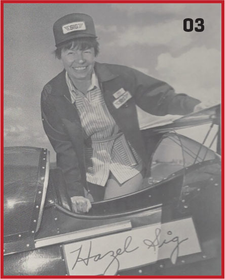 Woman smiling in a vintage airplane cockpit, wearing a cap and jacket.