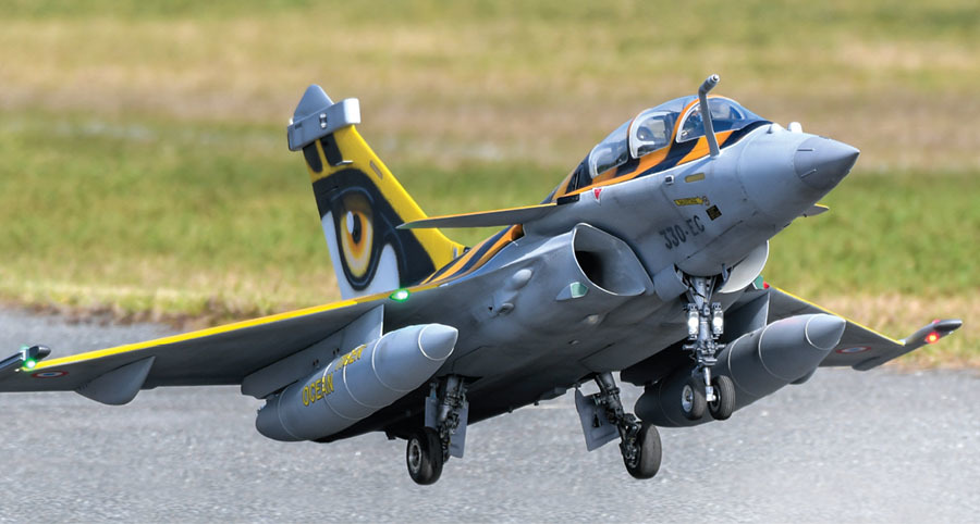 Gray jet taking off from runway, yellow tail with eye design.