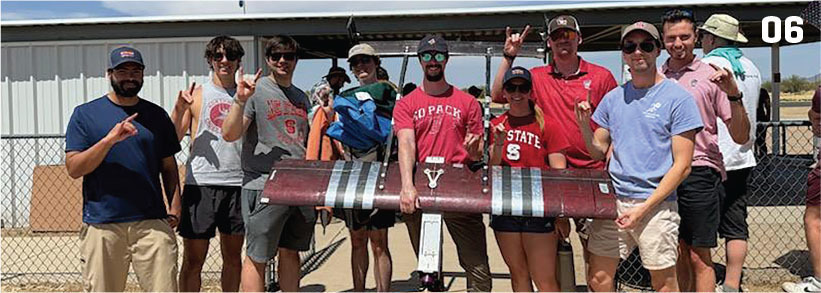 Group photo with a model aircraft, number 06 in corner.