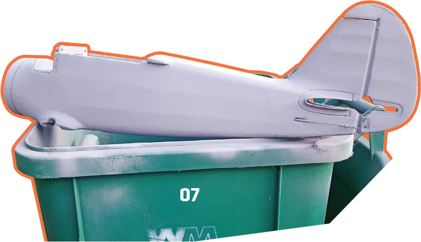 Model plane in a green trash bin, orange outline, number 07 visible.