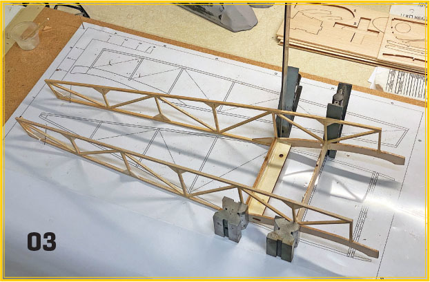 Wooden frame structure on blueprints, numbered 03 in the corner.