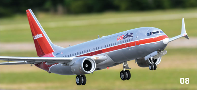 Airplane with red and gray livery taking off; "USAir" logo.