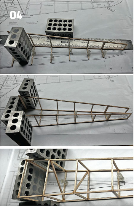 Model airplane frame construction with metal blocks and a ruler on a blueprint.