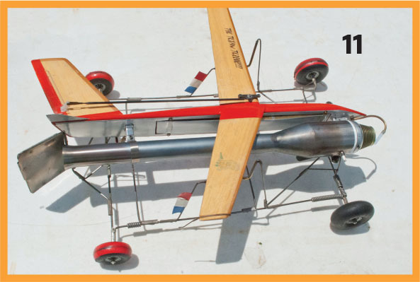 Model plane with wooden wings, metal body, and red wheels, labeled "11."