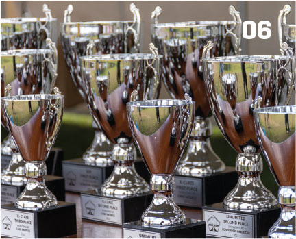 Silver trophies with labels, number 06 in corner.