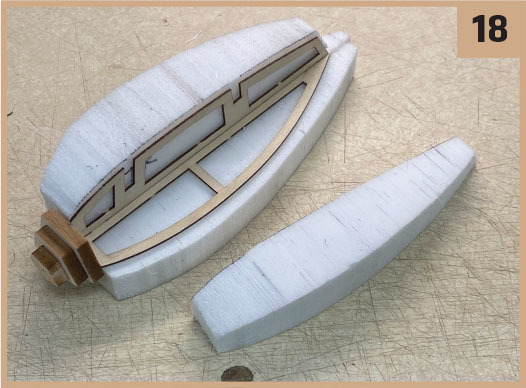 Foam boat hull pieces with wooden framework, labeled 18.