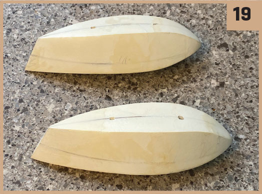 Carved wooden pieces on a speckled countertop, numbered 19.