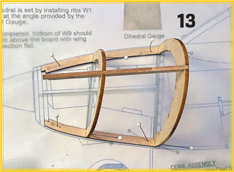Model airplane fuselage frame over assembly instructions, number 13 in bold.