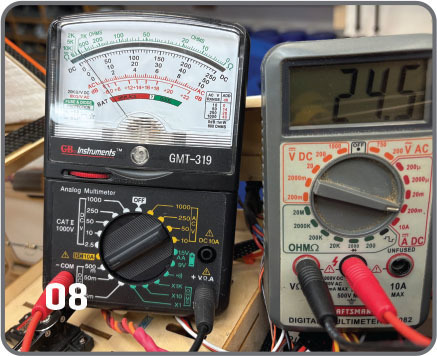 Analog and digital multimeters with wires, digital reads 246.