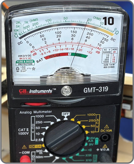 Analog multimeter GMT-319 with needle and dial, displaying various measurements.