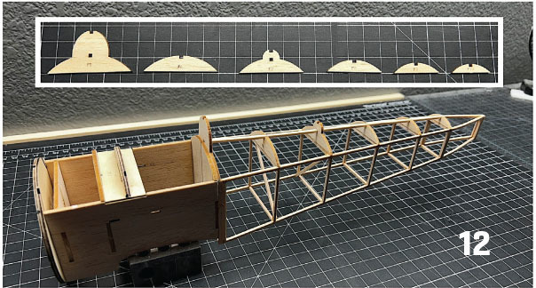 Wood airplane frame on grid mat, parts diagram above. Number 12 in corner.
