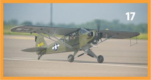 Green military airplane on tarmac, number 17 in corner.