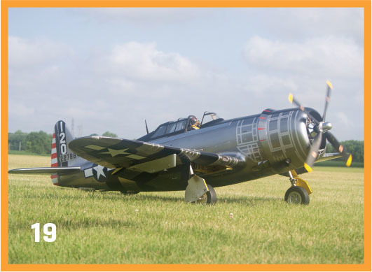 WWII-era fighter plane on grassy field, propeller spinning. Number 19 in corner.