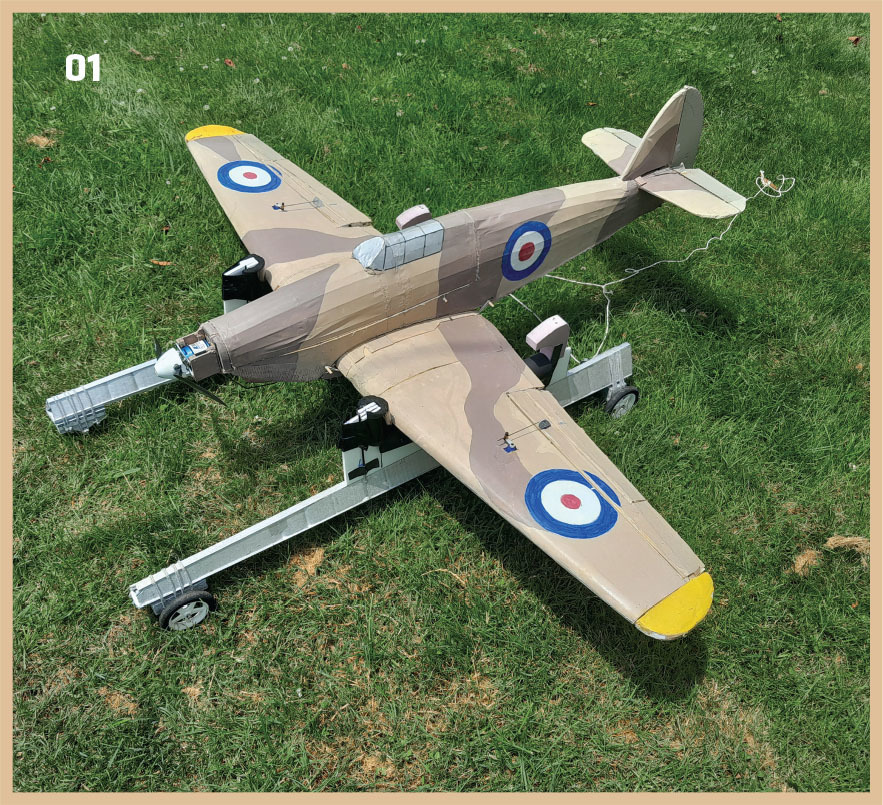 RC airplane with RAF roundels on grass; number 01 in corner.