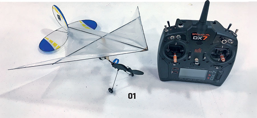 Toy plane beside a Spektrum DX7 remote control, labeled "01".