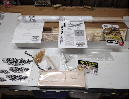 Model airplane building kit with instructions, decals, and parts on a table.
