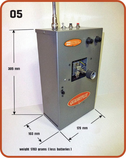 Gray metal box with "QUADRUPLEX" logo, dimensions marked, antenna on top.