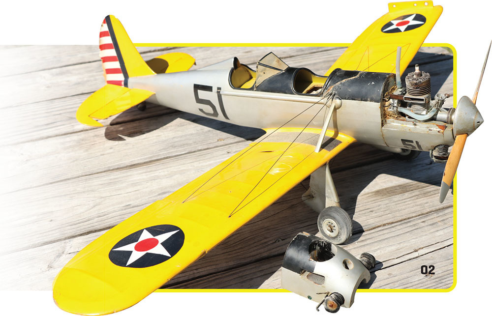 Model airplane with yellow wings on wooden surface, marked "51."