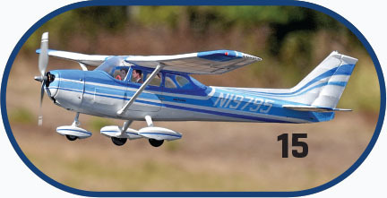 Blue and white model aircraft with number "15" on side, flying outdoors.