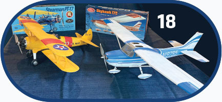 Model planes and boxes, including a yellow Stearman PT-17 and a blue Skyhawk 172.