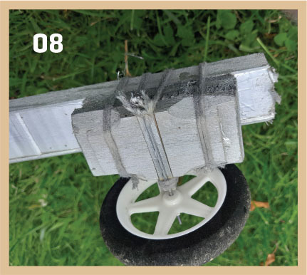 Wheel attached to a metal frame on grass, marked with the number 08.