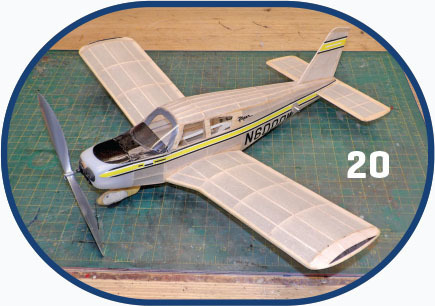 Model airplane with "N6000" on side, displayed on a green cutting mat, number "20" nearby.
