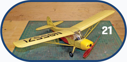 Yellow model airplane on cutting mat, number "21" on right.