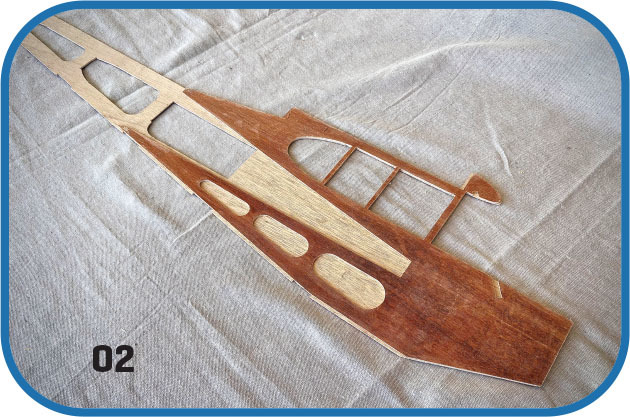 Wooden aircraft model part on fabric, marked "02."