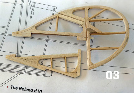 Wooden model plane parts on blueprint, labeled "03".