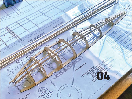 Model ship frame on blueprints, number 04 visible.