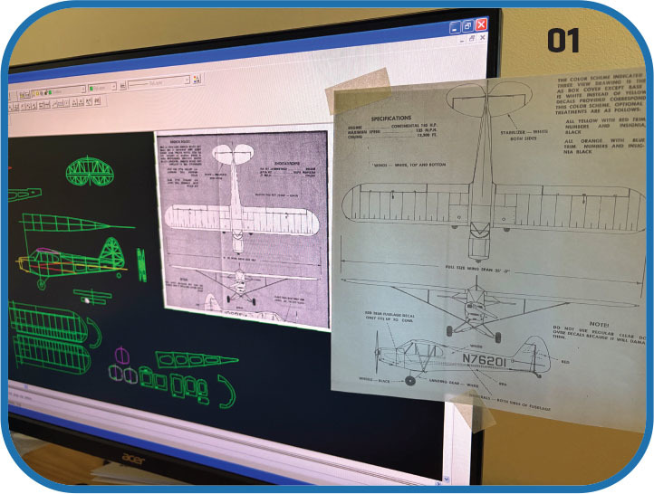 Computer screen with aircraft design, paper blueprint taped on.