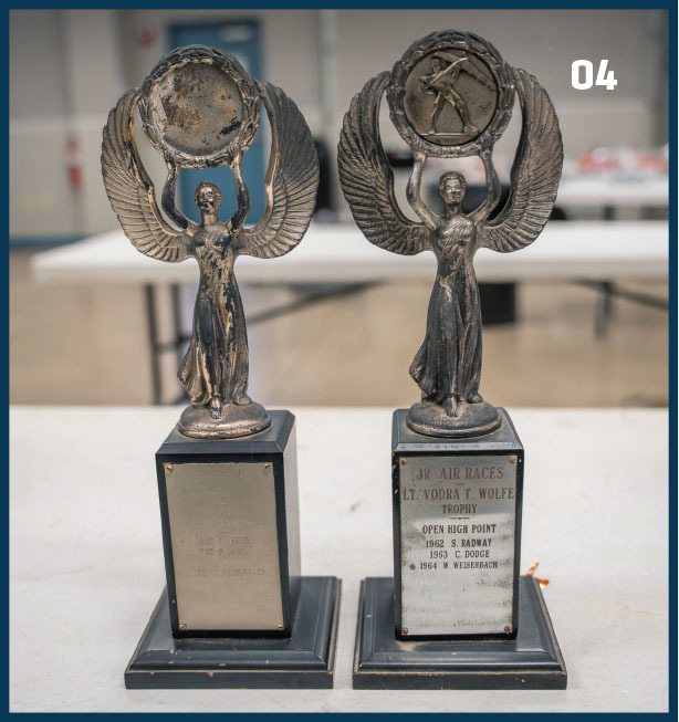 Two winged trophies on a table, labeled "Jr Air Races Lt. Vodra T. Wolfe Trophy."
