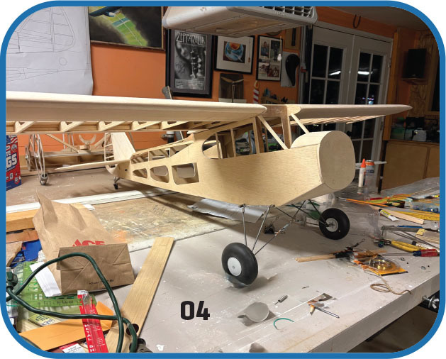 Wooden model airplane on cluttered workshop table.