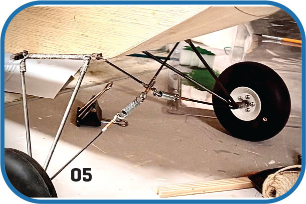 Model airplane landing gear with springs and wire, labeled "05".