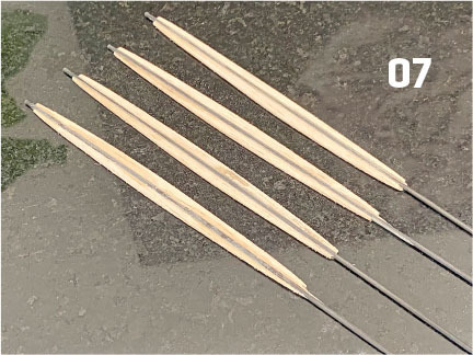 Tan skewers on a dark surface with the number 07.