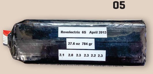 Black battery pack with labels: "Revolectrix 6S April 2013", "27.6 oz 784 gr", numbers below.