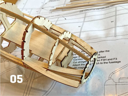 Wooden model framework on blueprint paper, number 05 visible.