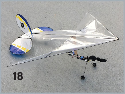 Model glider with shiny wings, two wheels, and blue accents. Number 18 on the ground.