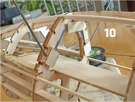 Wooden model ship frame with text "10" in the background.