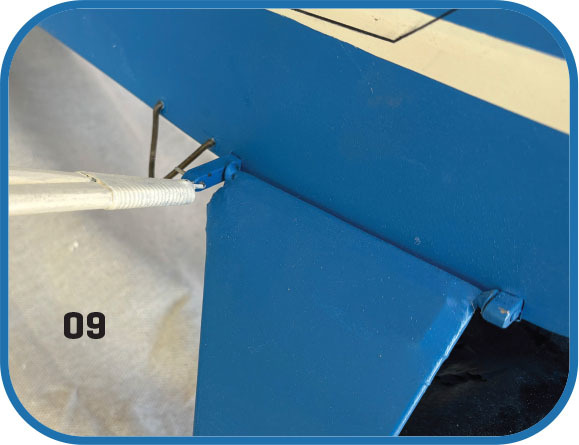 Blue metal structure with white rod attached. Number 09 is visible.