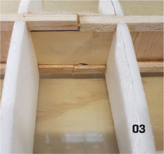 Foam and wood structure with number "03" in black text.