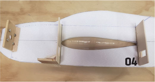 A foam airplane body with wood pieces and "04" text visible.