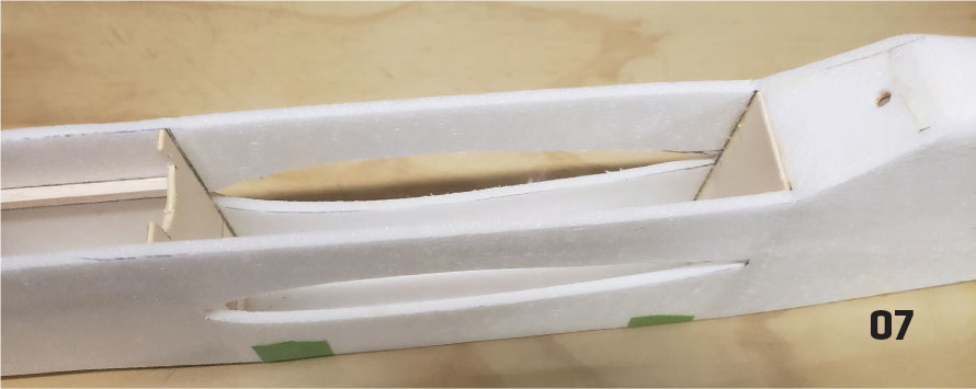 White model airplane fuselage with cutouts, marked "07" on beige background.